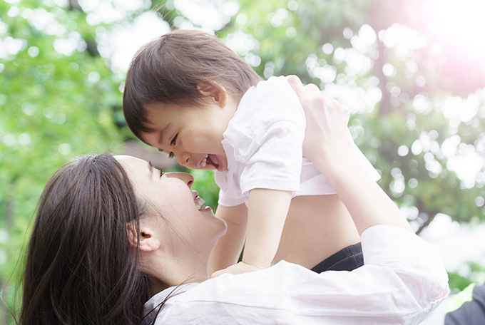 子ども抱き上げる女性